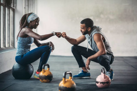 woman fist bumping personal trainer